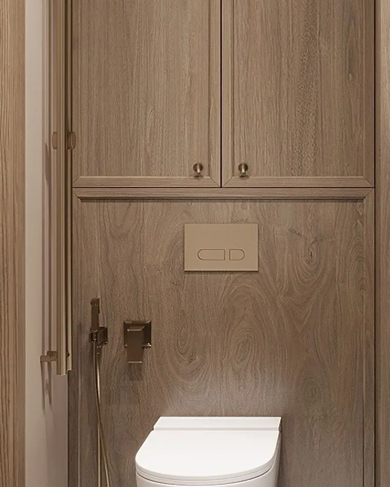 Brass fittings and a flush plate on a wood-panelled wall